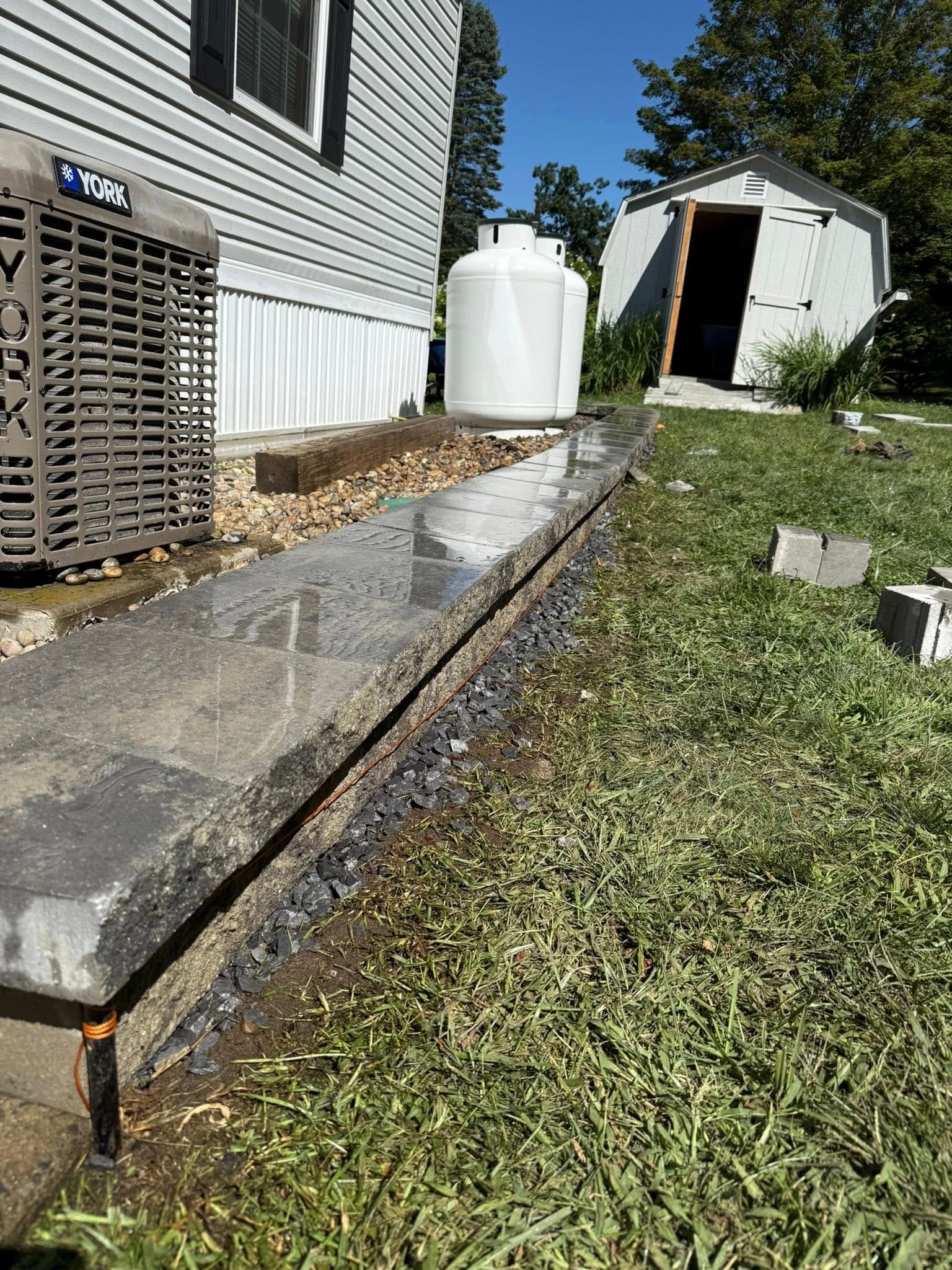 Past Projects 3 foundation stone border, landscape edging, drainage improvement, hardscape design, retaining edge, home exterior, stone wall, landscape border, water management, house foundation, outdoor design, curb appeal, hardscape installation, stonework